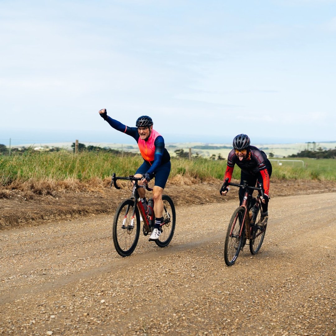 Two riders on a gravel road in long sleeve cycling kit