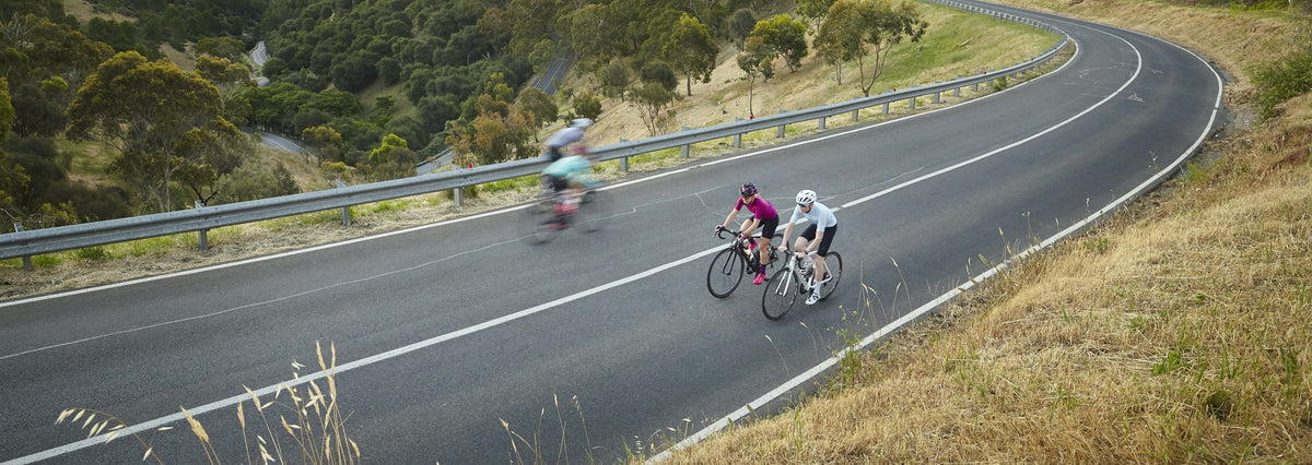 Cyclists riding together on an open road in Cycle Closet road kit